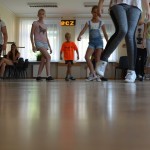 zdjęcie wykonane w sali. na zdjęciu grupa dzieci ucząca się układu choreograficznego