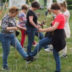 panie z kijkami nordic walking wykonują ćwiczenia rozgrzewkowe