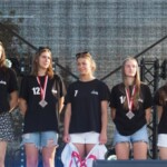 na scenie stoi pięć dziewczyn obok siebie, na szyjach mają medale