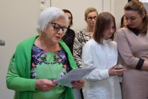 na zdjęciu kobieta stoi i czyta przemowę z kartki