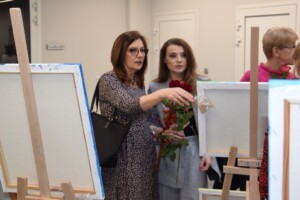 na zdjęciu dwie kobiety oglądają wystawione obrazy