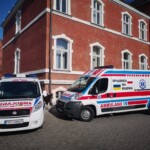 na zdjęciu dwie karetki stojące obok Urzędu Miasta