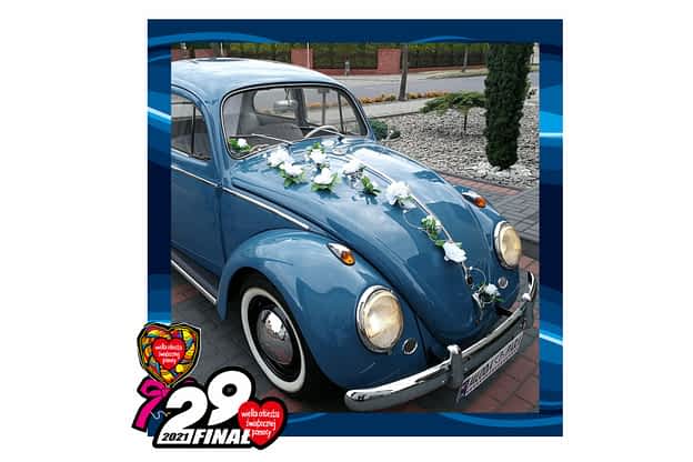 na zdjęciu w niebieskiej ramce 29 finału wośp stary, odpicowany błękitny volkswagen garbus przystrojony kwiatami