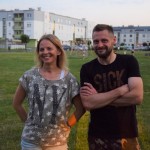 Zdjęcie zostało wykonane na dworze, znajdują się na nim dwie osoby po lewej kobieta ubrana w szarą bluzkę w gwiazki z napisem NY, po prawej mężczyzna ubrany w czarną bluzkę napisem SICK