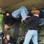 tancerze na scenie, jedna z nich robi salto w tył